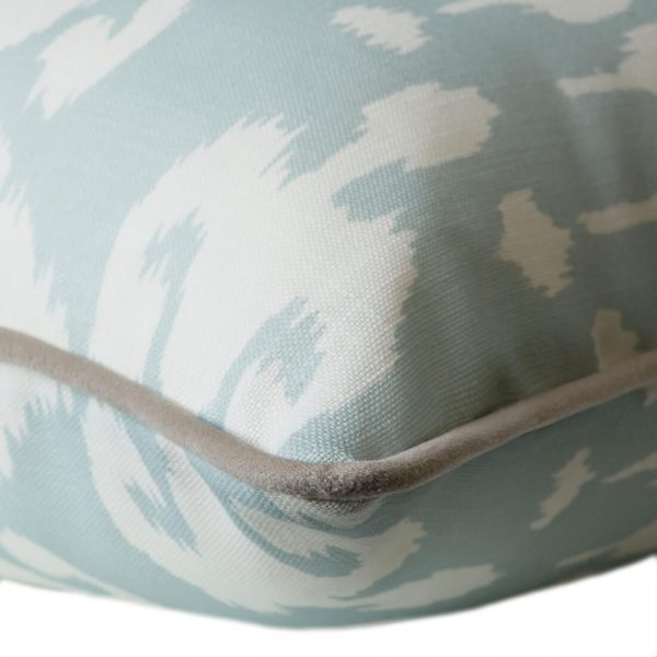 Outdoor cushion in bold, pale blue ikat design with grey piping
